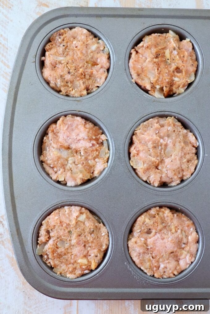 Ground turkey meatloaf mixture pressed into a muffin tin