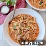 Overhead image of pasta in mushroom sauce in bowl with fork