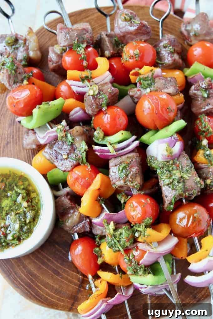 Grilled steak and vegetable skewers on wood cutting board