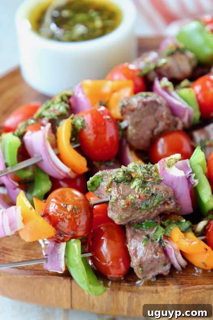 Steak kabobs with veggies on wood board