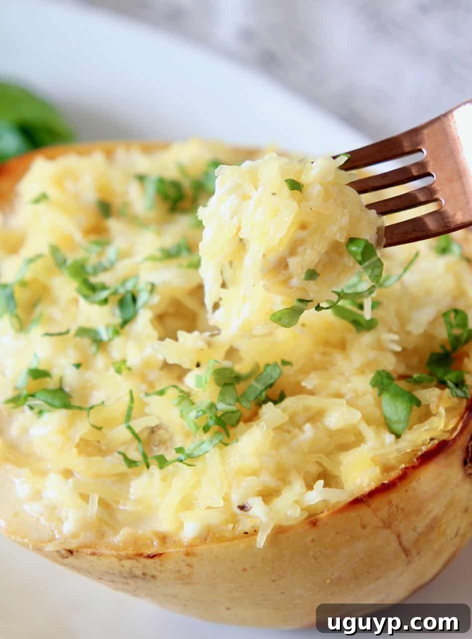 Spaghetti squash mac and cheese in a squash shell with fork dipped into the squash, showcasing a healthy comfort food alternative