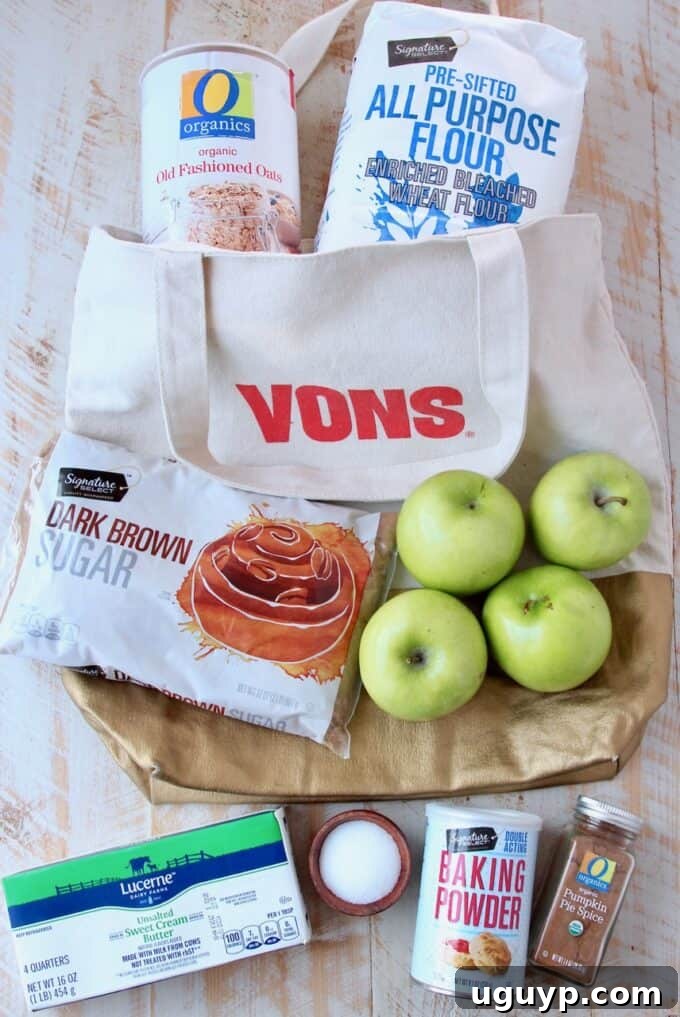 A selection of fresh, high-quality ingredients for making pumpkin spice apple oatmeal bars, including old-fashioned oats, all-purpose flour, dark brown sugar, pumpkin pie spice, cold butter, and crisp apples.