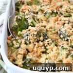 Broccoli casserole with Ritz cracker topping in dish with serving spoon