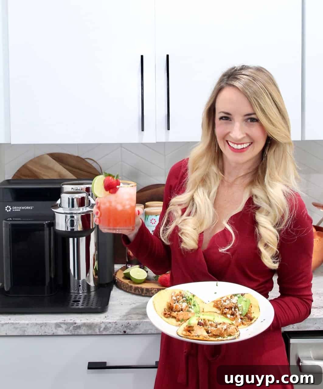 Woman holding a plate of Chipotle Chicken Tacos and a Strawberry Margarita