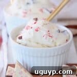 scoop of peppermint bark ice cream in white bowl with gold spoon