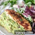guacamole stuffed chicken on plate with salad