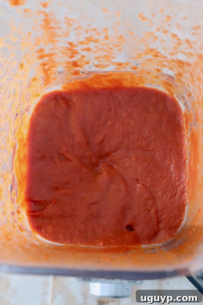Smooth, vibrant red enchilada sauce blended in a high-speed blender.