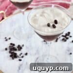 two espresso martinis on marble serving tray with coffee beans