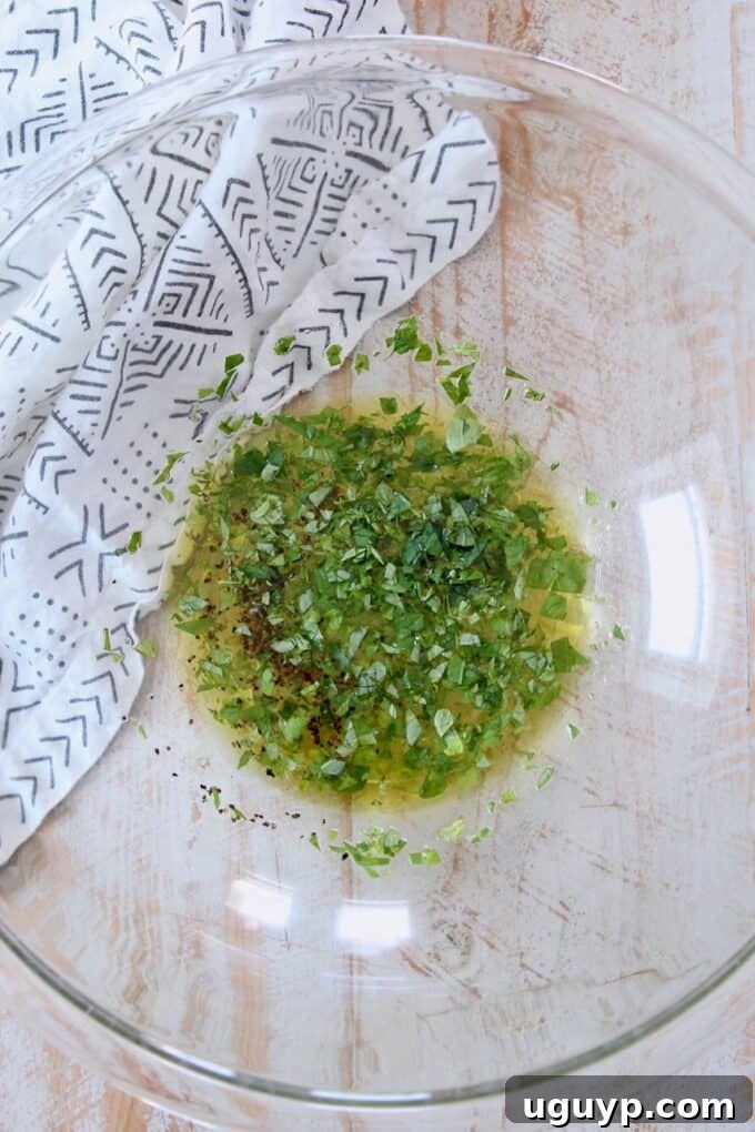 A glass bowl filled with the vibrant lemon herb dressing, ready for the salad components.