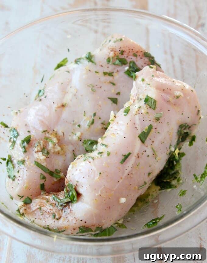 chicken breasts in bowl with lemon herb marinade
