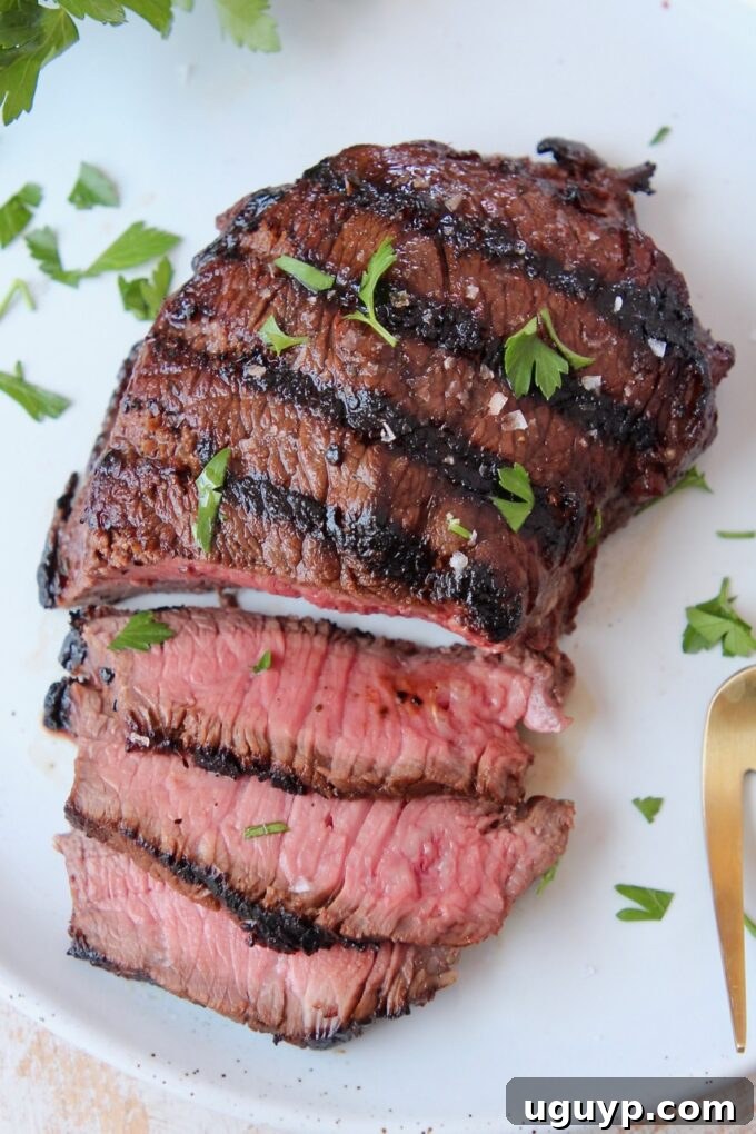 A perfectly grilled and sliced sirloin steak arranged elegantly on a white plate, showcasing its tender texture.