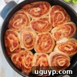 cooked pizza rolls in black baking dish