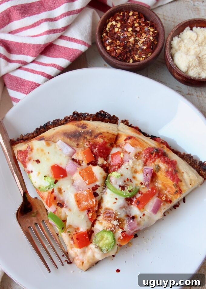 two slices of pan pizza on white plate with fork, showing crispy cheese edge