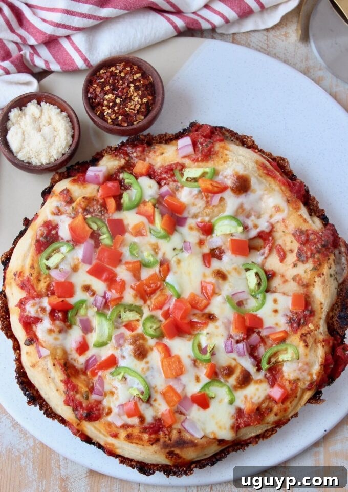 cooked pan pizza topped with colorful veggies on marble serving tray