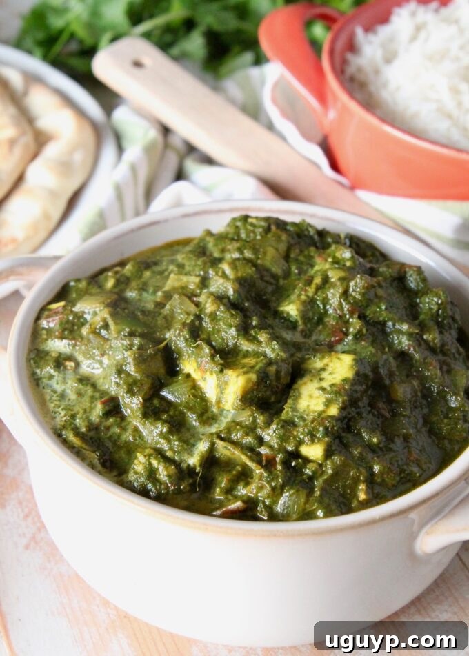 Creamy Palak Paneer served in a white bowl, garnished with a swirl of cream.