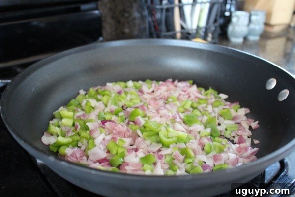 diced bell peppers and onions in a skillet