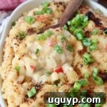 cajun macaroni and cheese in baking dish with serving spoon