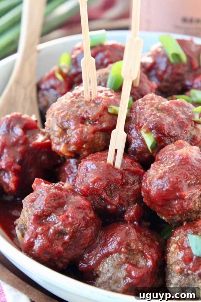 A bowl of easy BBQ meatballs, garnished with green onions, with toothpicks inserted for serving as an appetizer.