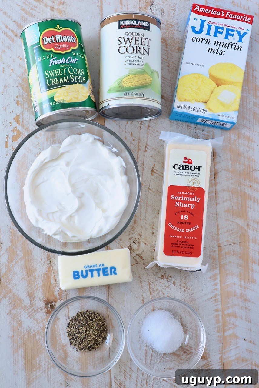 Ingredients laid out for making the easy cheesy corn casserole, including Jiffy mix, canned corn, sour cream, butter, and Cabot cheddar cheese.