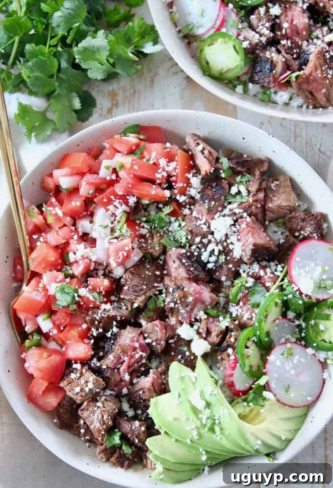 A vibrant Carne Asada bowl filled with grilled steak, diced tomatoes, and sliced avocado, showcasing a healthy and flavorful meal.