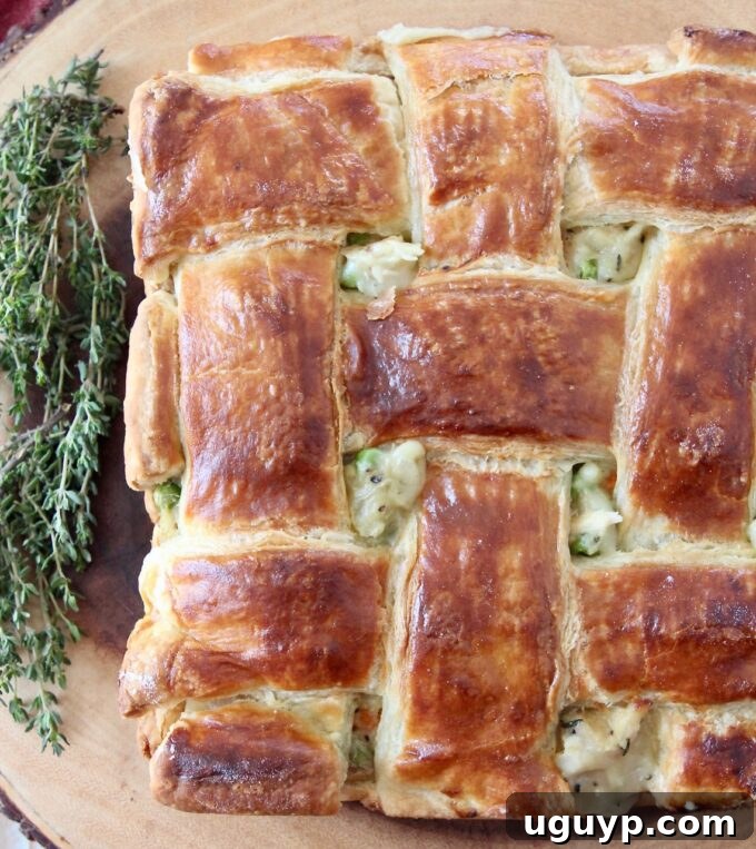 A golden-brown chicken pot pie with a flaky puff pastry crust, showcasing a delicious and comforting meal.