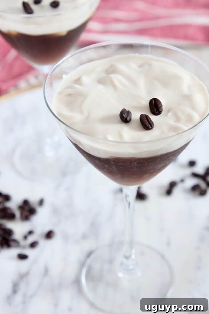 Two elegant Espresso Martinis garnished with coffee beans, served on a stylish marble tray.