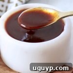 stir fry sauce in small white bowl with gold spoon dipped into the sauce