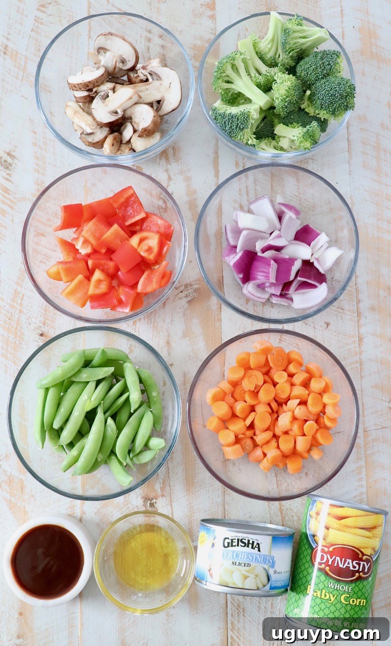 A colorful array of fresh stir fry vegetable ingredients laid out on a wooden cutting board.