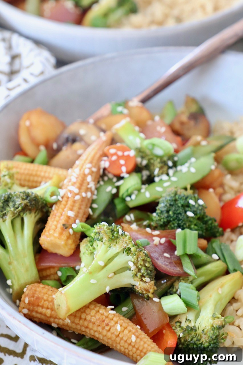 A beautifully presented bowl of easy stir fry vegetables with a fork.