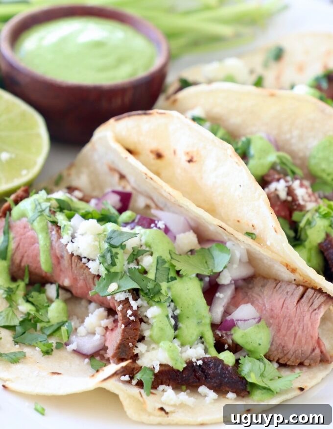 steak tacos on plate with creamy cilantro sauce