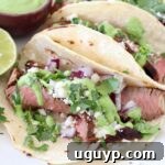 steak tacos on plate with lime and cilantro