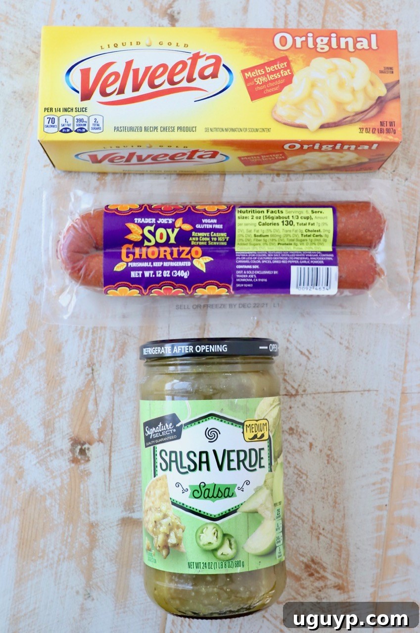 The three simple ingredients for an easy chorizo queso dip: a block of Velveeta cheese, ground chorizo sausage, and a jar of green salsa verde
