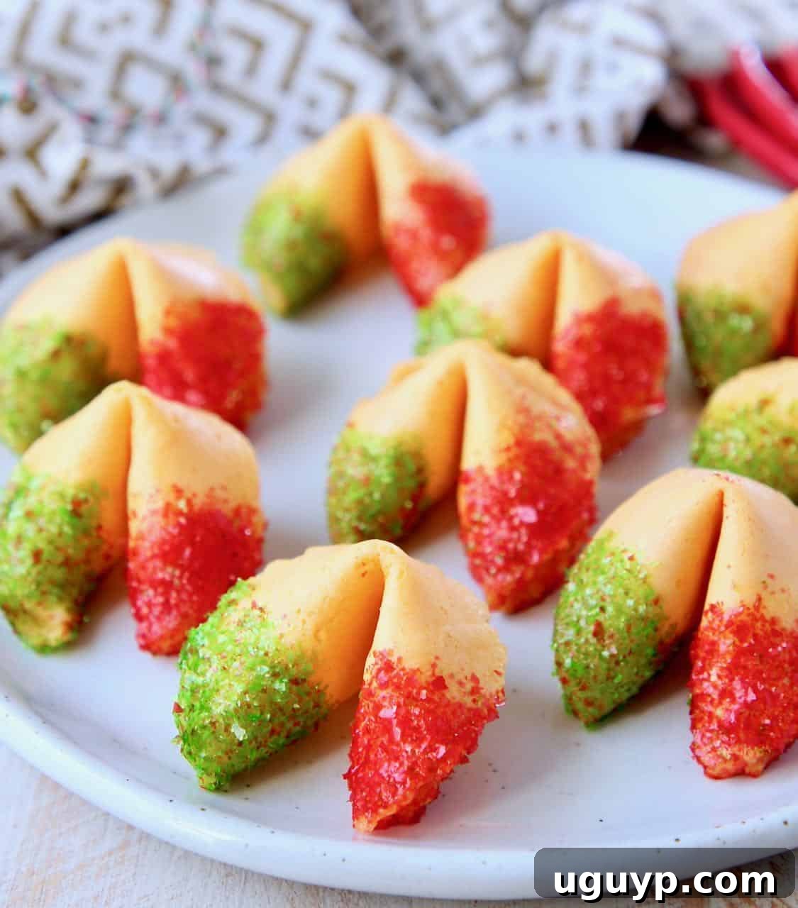Close-up of a stack of glitter fortune cookies, showcasing their vibrant colors and shimmer on a white plate.