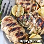 Beautifully sliced grilled Greek chicken served on a plate with fresh lemon slices, showcasing the dish ready to eat.