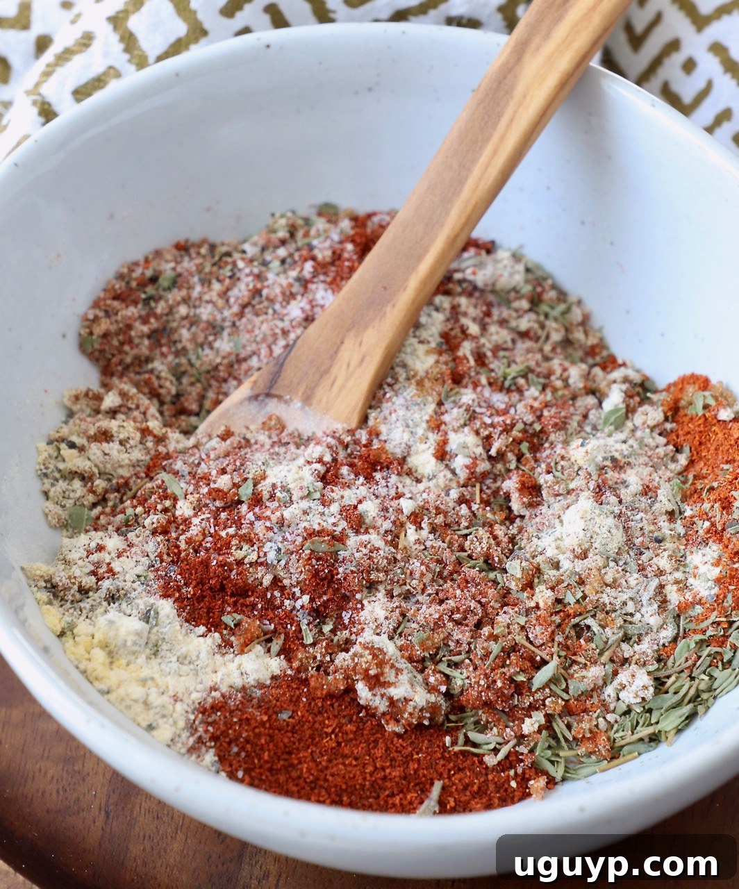 A bowl of delicious homemade pork chop seasoning blend with a wooden spoon, ready to infuse your meals with incredible flavor.