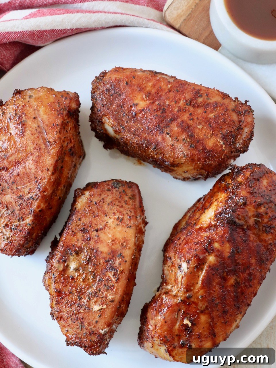 A beautifully smoked pork chop presented on a round white plate, ready to be enjoyed.