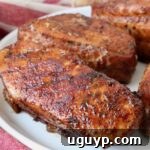 Seasoned smoked pork chops on a plate, ready to be served.