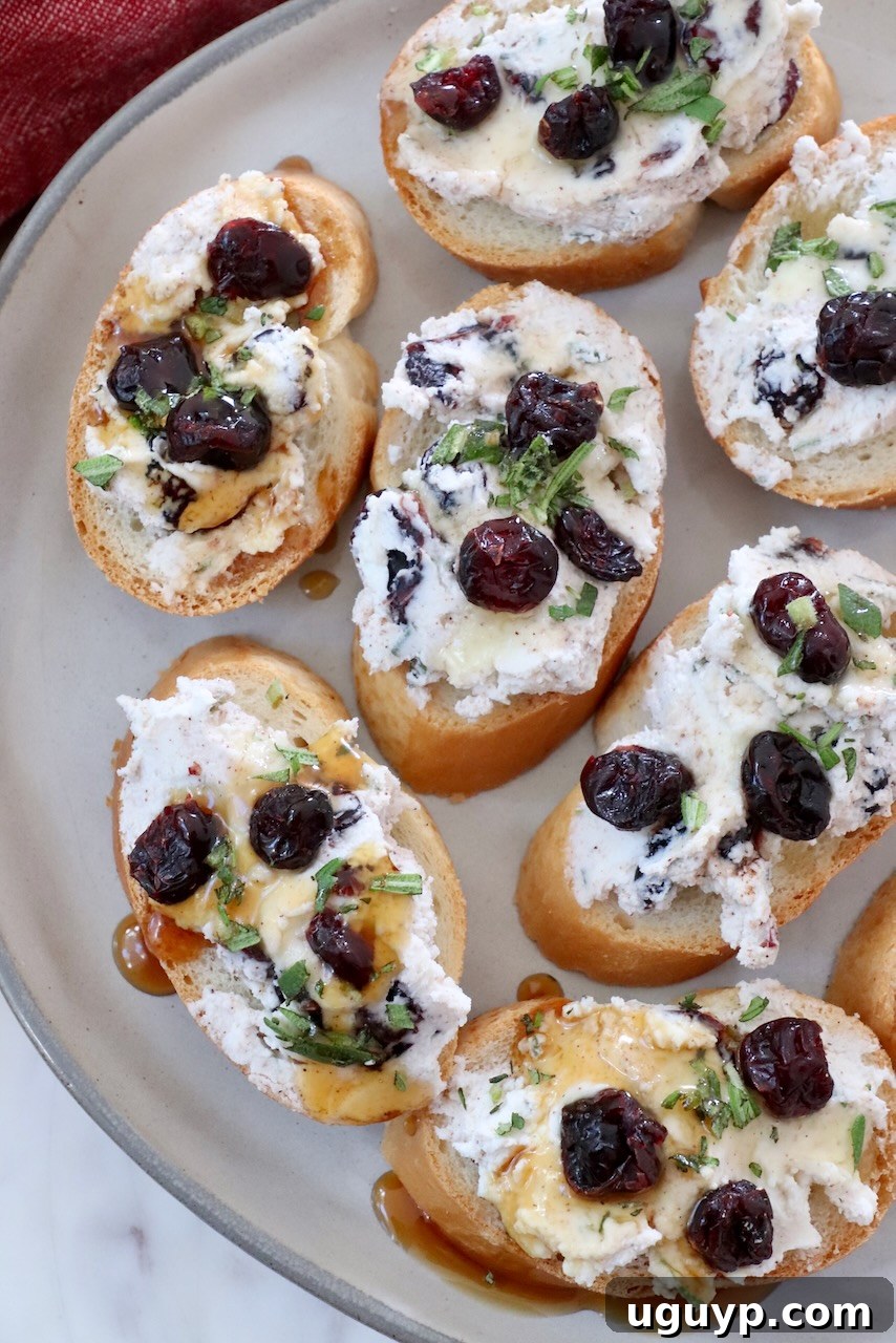 A festive platter of cranberry goat cheese crostini, artfully arranged and ready for a holiday party.