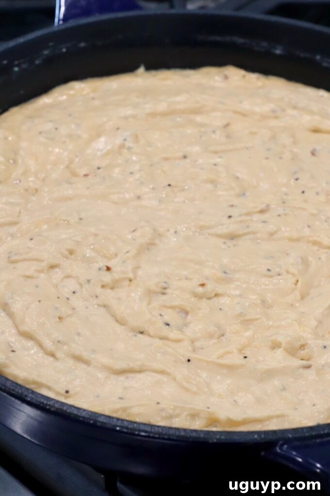 A smooth, perfectly melted cheesy sauce ready for pasta in a cast iron skillet.