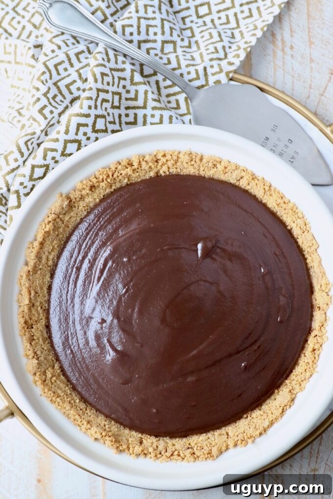 The assembled chocolate pie with its rich filling in the graham cracker crust, placed in a pie plate and ready for refrigeration.