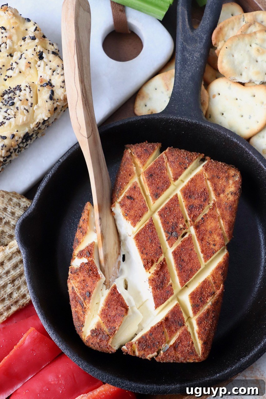 wooden knife in block of smoked cream cheese in cast iron skillet