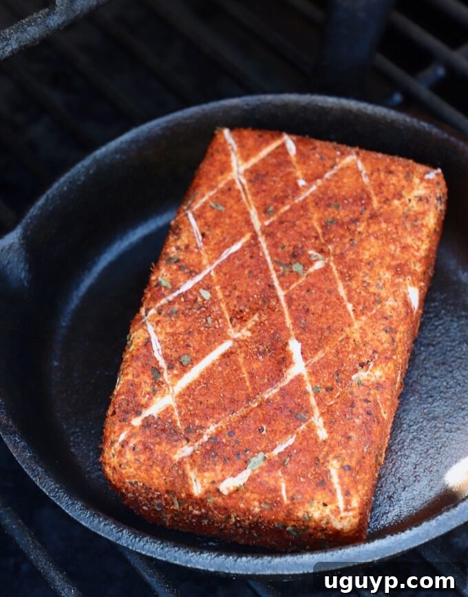 seasoned block of cream cheese in cast iron skillet