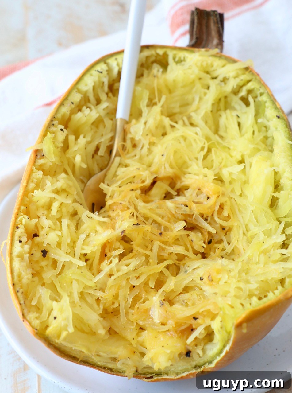 A plate of roasted spaghetti squash with a fork, showing the distinct noodle-like strands.