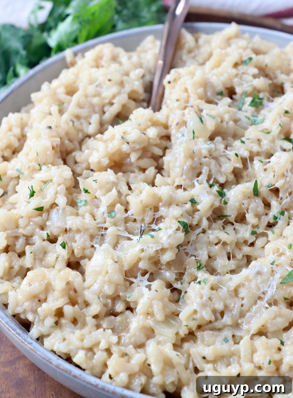 Creamy parmesan risotto in a bowl with a fork, ready to eat.