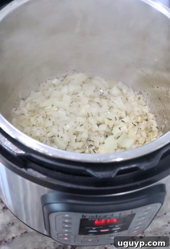 Sautéing diced onions, garlic, and thyme in an Instant Pot.