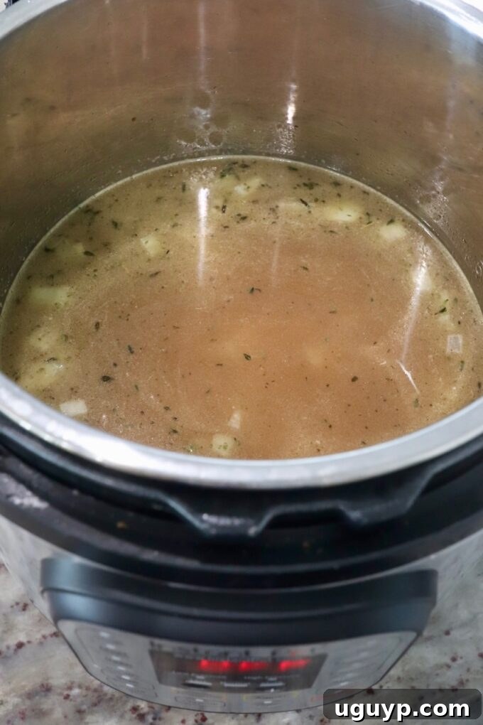 Adding chicken broth and Worcestershire sauce to the Instant Pot with rice.
