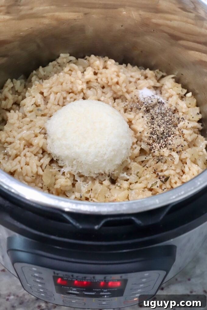 Stirring in parmesan cheese, salt, and pepper into cooked Instant Pot risotto.