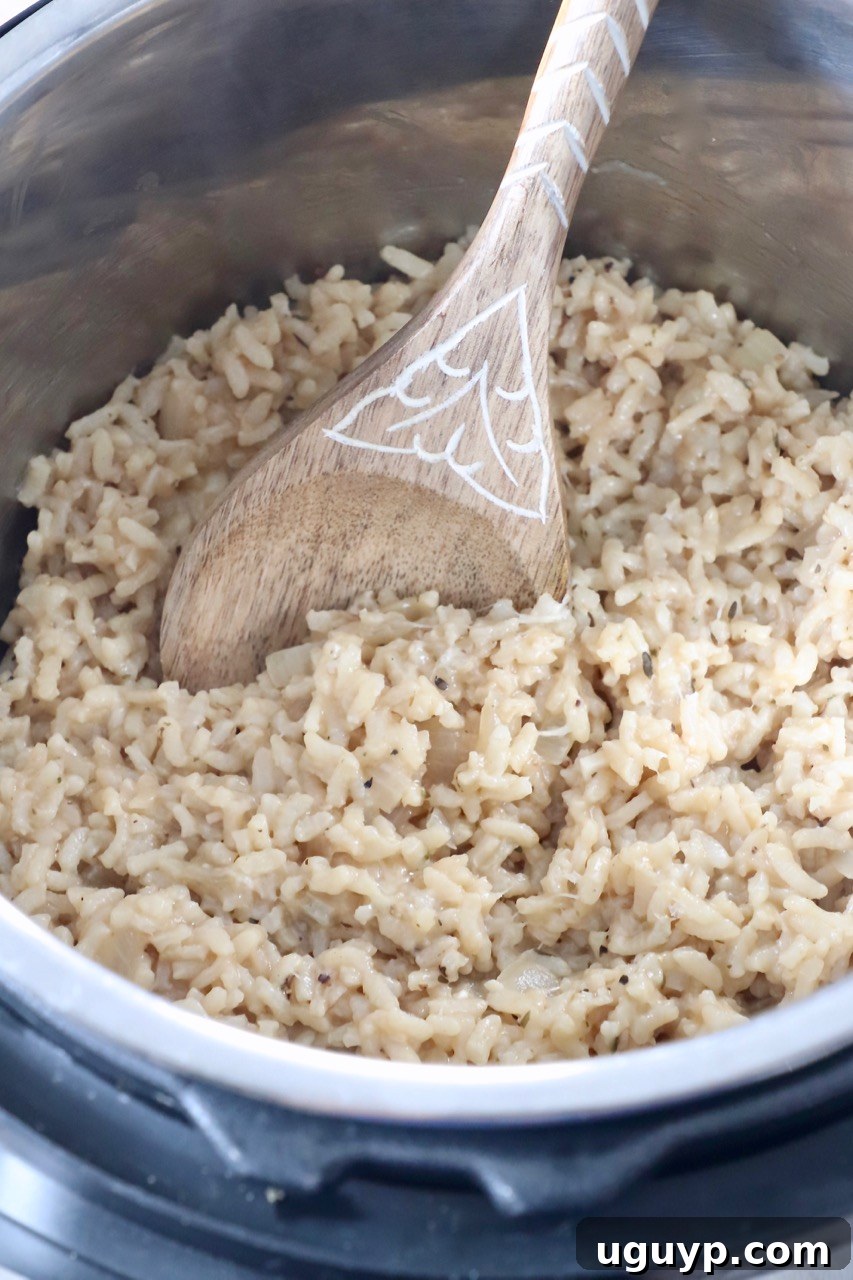 Serving spoon scooping creamy Instant Pot risotto from the pot.