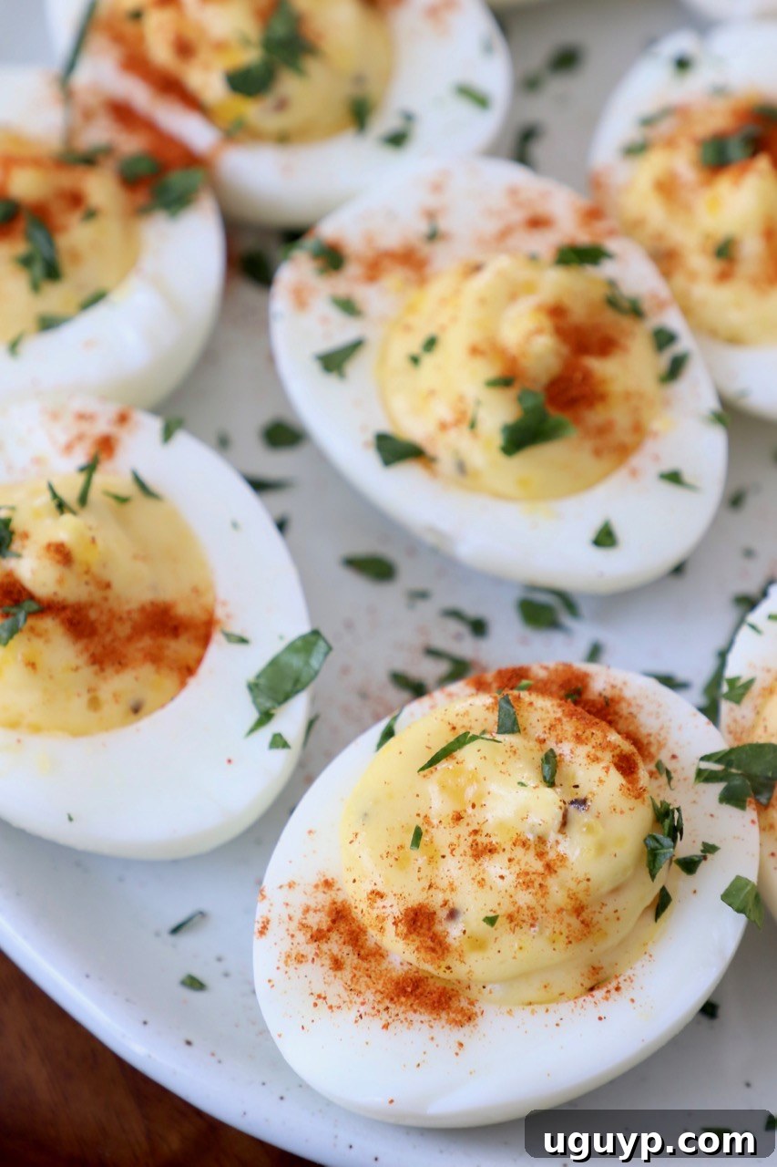 Classic deviled eggs garnished with fresh chopped parsley on an elegant white plate, ready to be served.