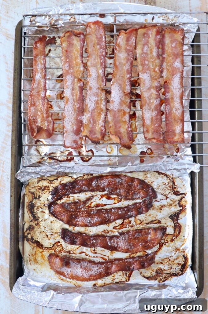 Darker, extra crispy bacon slices on a baking sheet, achieved with a longer baking duration.